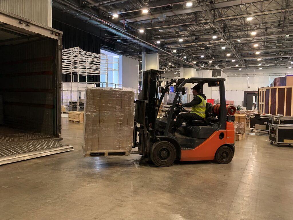 BV Exhibitions forklift operator moving a palletised exhibition shipment inside an exhibition hall